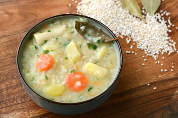 Krupnik, traditional Polish barley soup with vegetables in a bowl