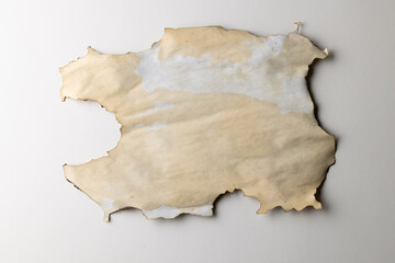 Burned and stained piece of paper with copy space on white background