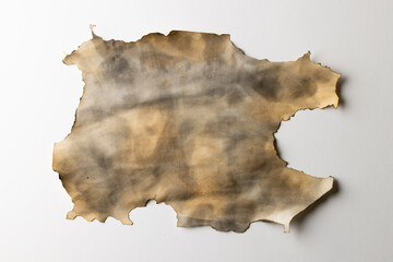 Burned and stained piece of paper with copy space on white background