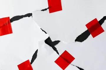  Ripped up pieces of white paper stuck together with red tape on black background © vectorfusionart