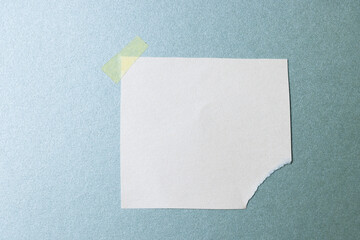 Ripped up piece of white paper with copy space on blue background