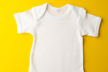 Close up of baby white t shirt with copy space on yellow background