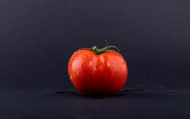 Tomato red. Tomatoes on a black background. Top view of tomatoes with Parsley leaf, side view.