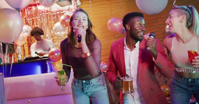 Video of diverse happy group of friends signing karaoke at a nightclub bar