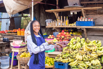 portrait of an african market woman smiling showing her goods