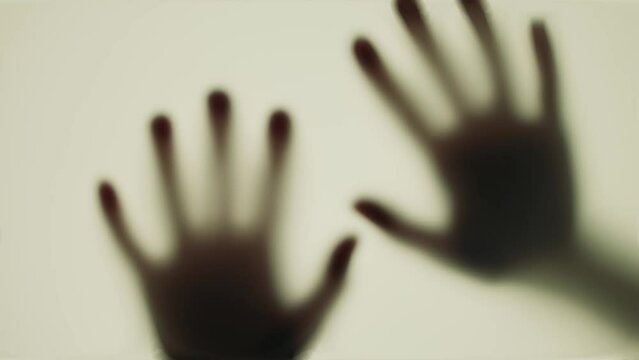 Hand scratching glass, monster behind door, evil ghost or walking dead, zombie. Thriller, horror concept