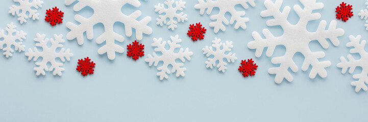 White and red snowflakes on a blue background, Christmas banner, Merry Christmas and Happy New Year concept, top view, copy space