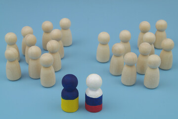Obraz premium Wooden people figures are divided into two parts, and leaders is painted in colors of Ukrainian and Russian flags. Agreement between Russia and Ukraine, stopping hostilities and making peace concept.