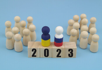 People figures are divided into two parts, and leaders with numbers 2023 on wooden cubes. Agreement between Russia and Ukraine, stopping hostilities and making  peace concept.