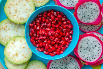 Pile of various types of fresh organic fruits (red berry strawberry, green apple, kiwi slice, orange and grapes fruit) isolated on wooden background. Healthy food boost immunity system concept.
