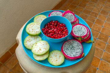 Pile of various types of fresh organic fruits (red berry strawberry, green apple, kiwi slice, orange and grapes fruit) isolated on wooden background. Healthy food boost immunity system concept.
