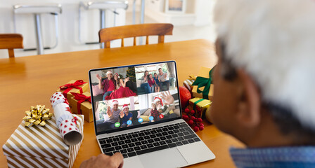 Senior biracial man having christmas video call with diverse people - Powered by Adobe