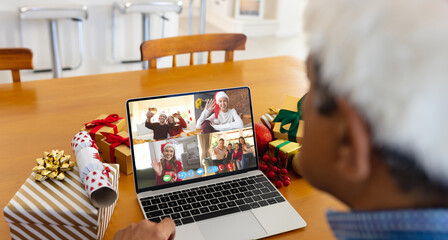 Senior biracial man having christmas video call with diverse people - Powered by Adobe