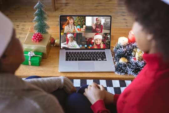 African american couple having christmas video call with diverse people