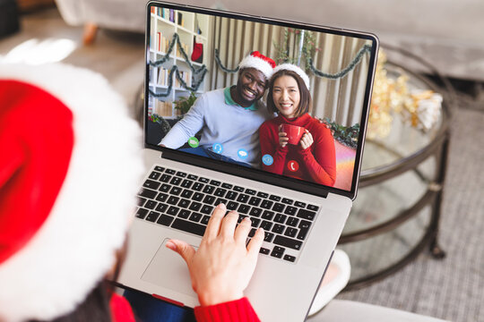Caucasian woman having christmas video call with diverse couple