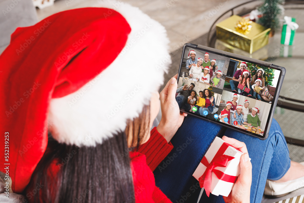 Poster Caucasian woman with santa hat having video call with happy diverse friends