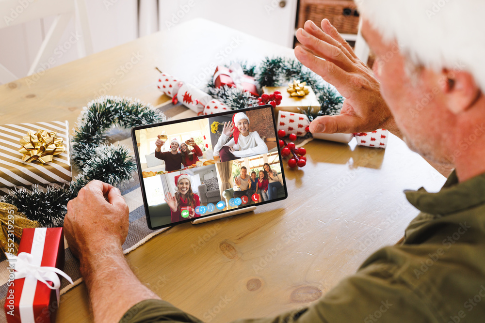 Poster Caucasian man with santa hat having video call with happy caucasian friends