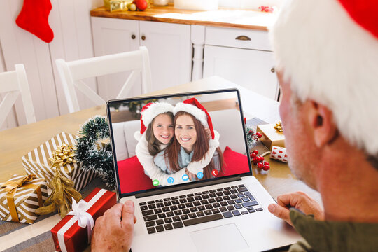 Caucasian man with santa hat having video call with happy caucasian couple