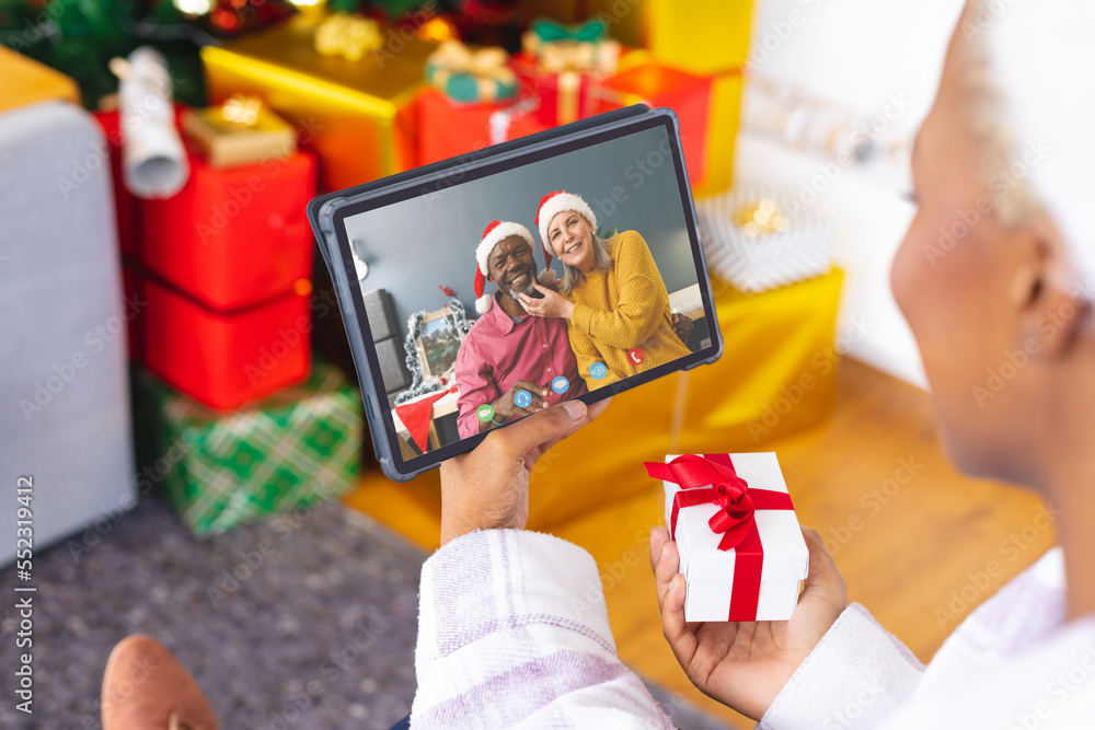 Canvas Prints African american woman with christmas decorations having video call with happy diverse couple