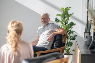 Man talking to a blonde woman and looking involved