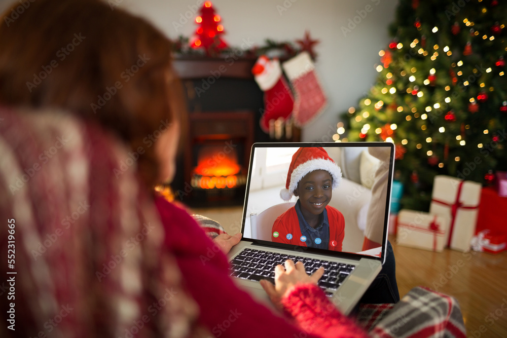 Poster Caucasian woman with christmas decorations having video call with happy african american boy