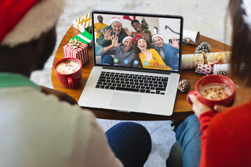 Diverse couple with santa hats having video call with happy diverse friends - Powered by Adobe