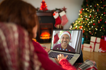 Caucasian woman with christmas decorations having video call with happy biracial man - Powered by Adobe