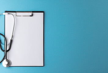 Composition of stethoscope with clipboard on blue background with copy space