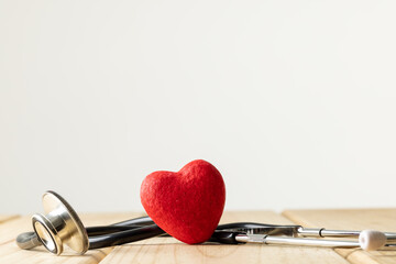 Composition of stethoscope and red heart on white background with copy space
