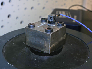 Triaxial accelerometer stuck on steel cube, screwed on an electrodynamic shaker.