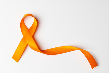 Close up of orange ribbon on white background with copy space