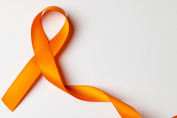 Close up of orange ribbon on white background with copy space
