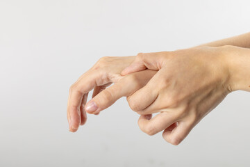 Close up of hands of caucasian woman massaging her thumb on white background with copy space