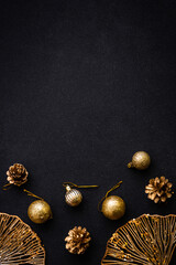 Naklejka premium Christmas flat lay background with golden holiday decorations. Top view on black with copy space.