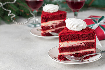 Two servings of Red Velvet cake, wine and gifts on gray background, dessert for the New Year