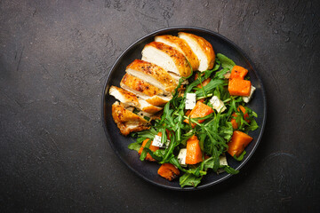 Chicken salad with pumpkin and arugula. Dash diet, keto diet meal. Top view image.