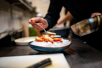 chef cooking crab legs with caviar on kitchen