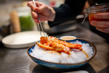 chef cooking crab legs with caviar on kitchen