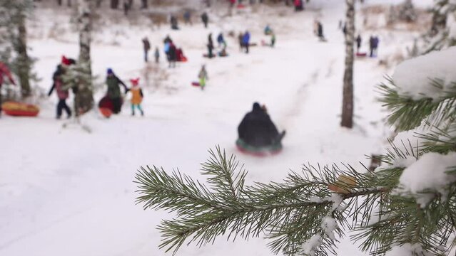 Funny people ride downhill in winter in defocus. Cheerful friends, holidays, winter fun, snow-covered mountain slopes. Video, footage for the background, intro, titles. UHD 4K.