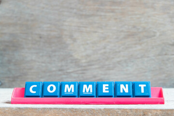 Obraz premium Tile alphabet letter with word comment in red color rack on wood background