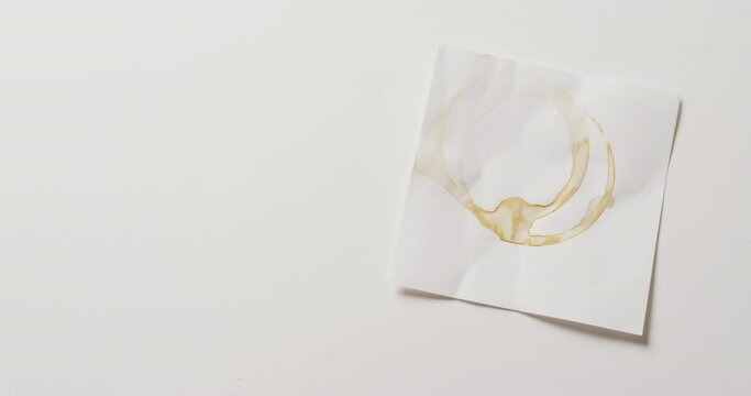 Video close up of piece of paper with coffee mug ring stains on white background