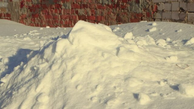 Snow fall in the same place and forms a large snowdrift. Large snowdrifts around after a snowstorm, sunny day. City life, heavy snowfall. UHD 4K.