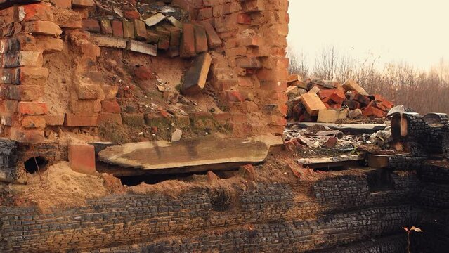 Charred black logs and a destroyed stove, the remains of a burned-out house. An abandoned wooden building, a consequence of the war, bombing, rocket attacks. Ruins, people in evacuation. UHD 4K.
