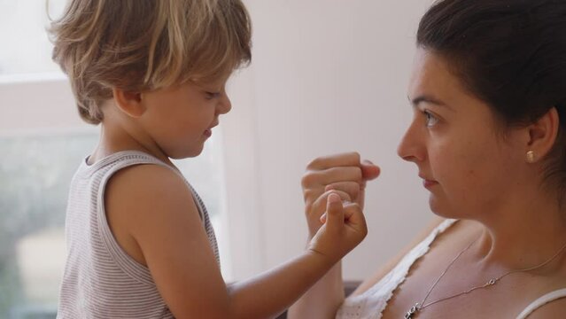 Mother and son doing pinky swear. Parent and child promise. Mom and kid relationship based on trust. Education commitment concept