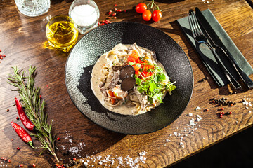 Black Angus beef tagliatelle pasta with fresh black truffles and parmegano. Delicious healthy traditional food closeup served for lunch in modern gourmet cuisine restaurant