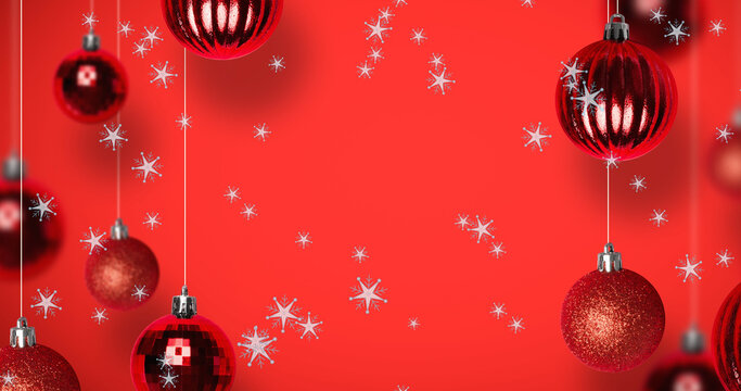 Image of snow falling over christmas bauble decorations on red background