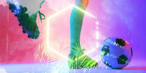 Low section of caucasian male player kicking ball by illuminated plants and hexagon, copy space