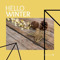 Square image of hello winter text with pine cones on wooden desk over yellow background