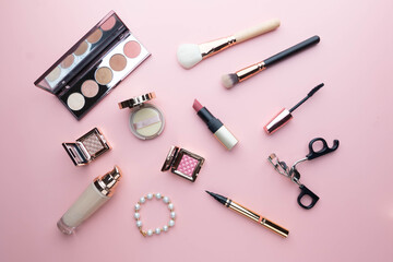 Top view of beauty cosmetic makeup accessories on pink background. Fashion woman make up product, brushes, lipstick, powder, foundation collection.