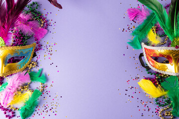 Colourful mardi gras beads, feathers and carnival masks on blue background with copy space - obrazy, fototapety, plakaty
